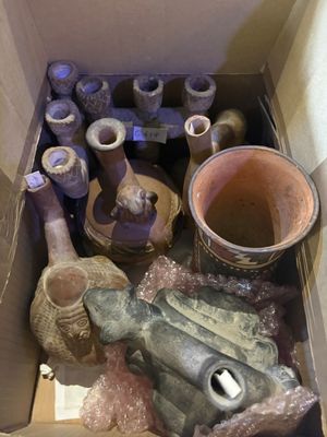 une boîte remplie de vases et d'autres objets qui s'y trouvent