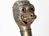 un gros plan d'une canne ornée d'une tête d'animal