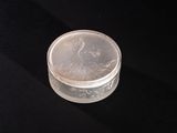 a small glass container with a lid on a black surface