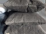 three pillows are stacked on top of each other on a bed
