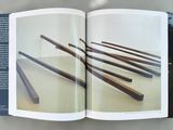 an open book with a picture of a bunch of wooden sticks