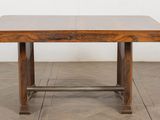 une table en bois avec un plateau en verre, posée sur un parquet