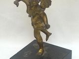 statue of an angel holding a bird on a black base