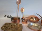 many different types of copper pots and pans on the table