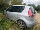 a silver car is parked in the grass next to some trees