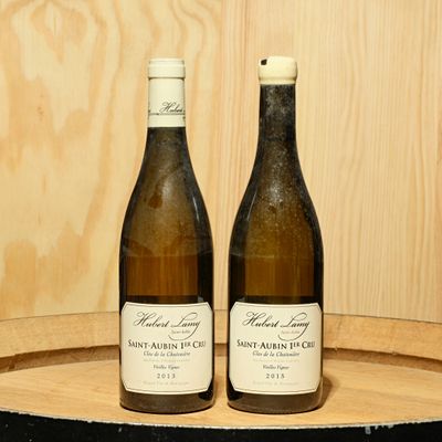 deux bouteilles de vin posées sur un tonneau en bois