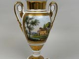 a vase with a painting on it sitting on a table