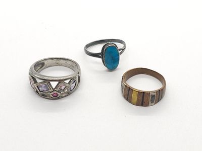 trois bagues et une bague ornée d'une pierre turquoise sur un fond blanc