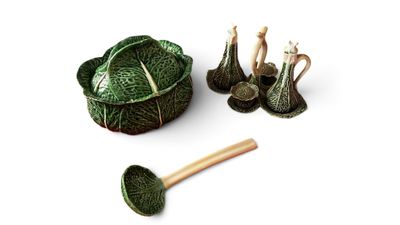 un chou vert et une cuillère en bois posés sur une surface blanche
