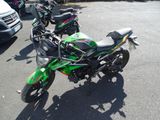 many motorcycles parked in a parking lot next to each other