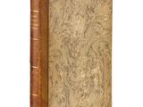 an old book with a brown cover sitting on top of a white surface