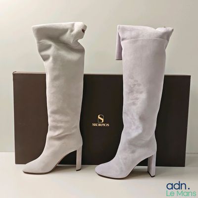 Les bottes blanches sont à côté de la boîte, sur la table.