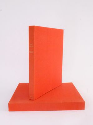 two orange books stacked on top of each other on a white surface
