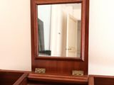 a wooden dresser with a mirror on top of it