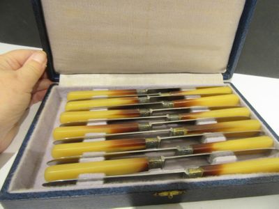 a person holding a box with a bunch of knives in it