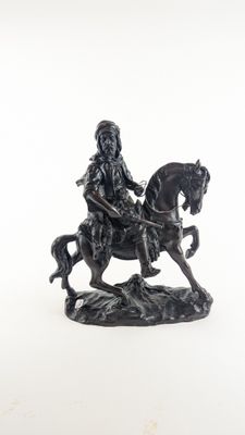figurine représentant un homme à cheval sur fond blanc