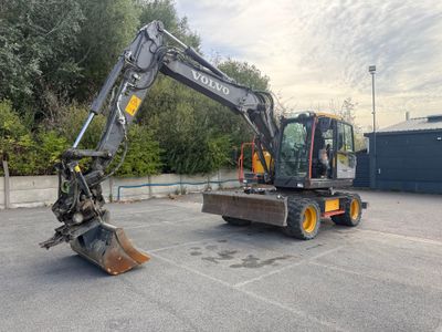 une petite excavatrice garée sur un parking