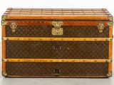 a brown and tan trunk sitting on top of a floor