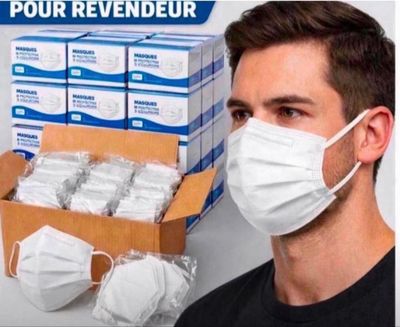 un homme portant un masque à côté d'une boîte de masques