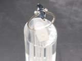 a ring with a blue stone sitting on top of a glass of water