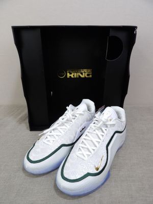 a pair of white and green sneakers in front of a black box