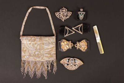 un sac à main, un peigne, des barrettes et d'autres objets disposés sur une table