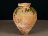 a large brown vase with a green plant growing out of it