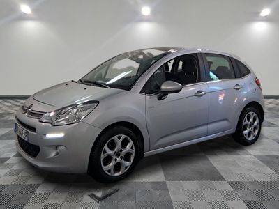 la petite voiture argentée est garée sur un carrelage à carreaux