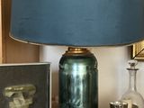 une lampe posée sur une table à côté d'un tableau