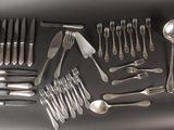 a lot of silverware on a table with spoons and spoons