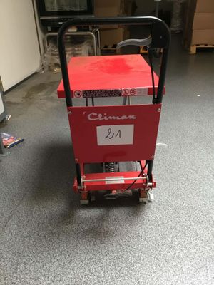 a red cart with a sign on it in a garage