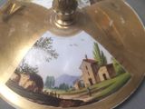 a gold plate with a picture of a farm scene on it
