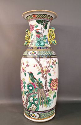 un grand vase orné d'un oiseau, posé sur une table