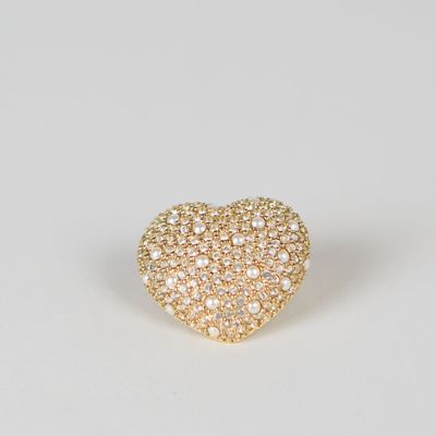 une bague en forme de cœur dorée, ornée de cristaux blancs sur fond blanc