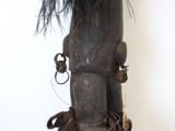 a wooden sculpture of a man with a feather on it ' s head
