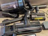 un aspirateur posé sur le sol à côté d'autres objets