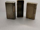 trois types différents de briquets posés sur une surface blanche