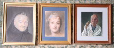 three framed portraits of older people on the wall