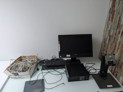 un bureau sur lequel se trouvent un écran, un clavier, une souris et d'autres appareils électroniques