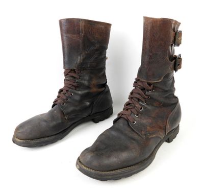 une paire de bottes en cuir marron à lacets, sur fond blanc