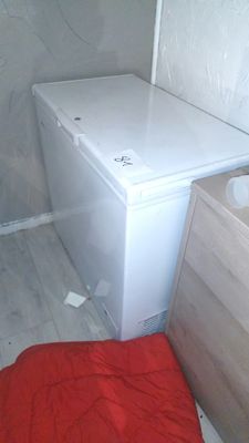 a white toilet sitting in a bathroom next to a wooden cabinet