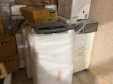 une pile de cartons et un ordinateur portable posés sur un chariot dans une pièce