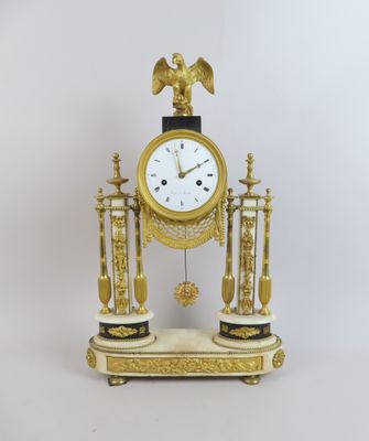 une horloge en or surmontée d'un aigle
