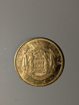 gros plan d'une pièce d'or sur une surface blanche