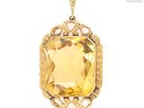 un gros plan d'un pendentif serti d'une pierre jaune