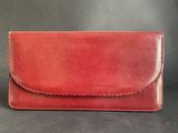 a red leather clutch bag with a long strap