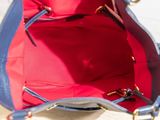 a blue and red purse sitting on a wooden table