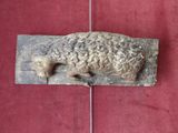 a sculpture of a sheep laying on a red surface