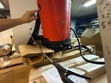 une personne tenant un seau rouge au sommet d'une pile de cartons
