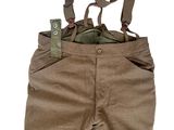 un pantalon marron avec des bretelles, dans lequel se trouve un téléphone portable